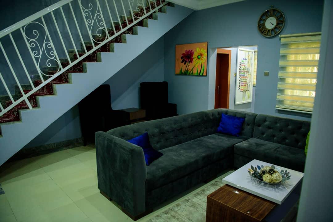 A communal lounge with sofas, a shared television and soft evening light